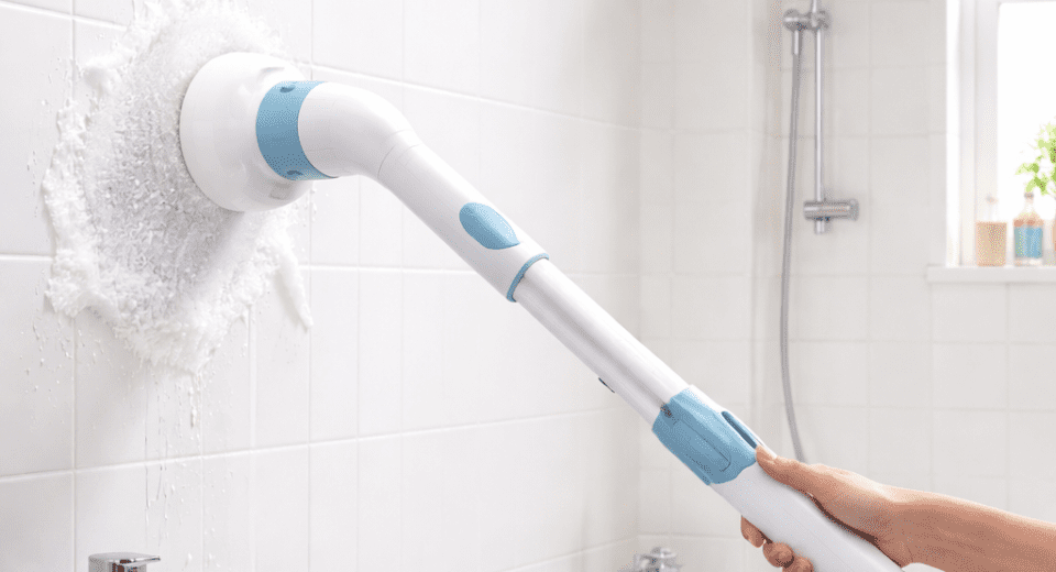 Cordless electric spin scrubber cleaning bathroom tiles and grout for easy bathroom cleaning
